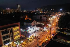 a city lit up at night with traffic on a street at May House Karon Beach in Karon Beach