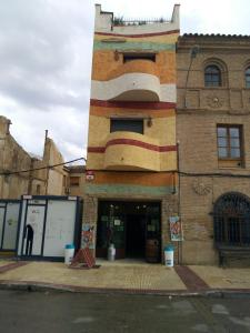 a building with a painting on the side of it at Alojamientos Dezerto Bardenas in Arguedas