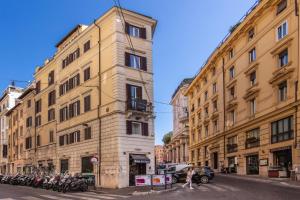 羅馬的住宿－Rome Art Hotel - Gruppo Trevi Hotels，一条城市街道上一座高大的建筑,上面有停放摩托车