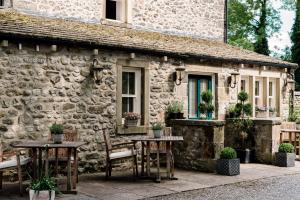 a stone cottage with tables and chairs in front of it at The Rectory Rooms, Studio 1 in Skipton