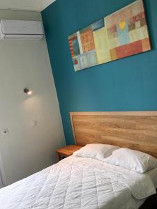 a bedroom with a bed and a blue wall at Hotel Kastoria in Thessaloniki