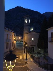 a building with a clock tower with a mountain in the background at Da Oreste Affittacamere in Fara San Martino