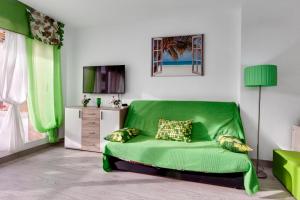- un canapé vert dans le salon doté d'une télévision dans l'établissement Apartment Studio Playa del Cura, à Torrevieja