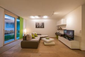 a living room with a couch and a tv at Ferienwohnung Robi in Fulpmes