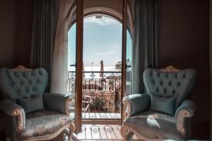 2 Stühle vor einem Fenster mit Balkon in der Unterkunft Seven Hills Palace & Spa in Istanbul