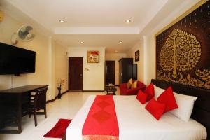 a bedroom with a large bed with red pillows at Sky Silk Decoration House in Patong Beach