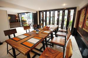 a dining room with a long wooden table and chairs at Sky Silk Decoration House in Patong Beach