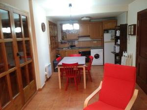 uma cozinha com uma mesa e cadeiras vermelhas em APARTAMENT DE LA LALI ESCALÓ em Escaló