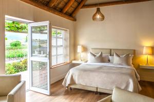 a bedroom with a bed and a large window at Rijk's Guesthouse in Tulbagh +34 photos