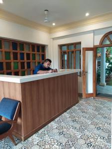 a man standing at a counter in a room at Vilasam in Mahabalipuram