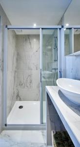 La salle de bains est pourvue d'une douche en verre et d'un lavabo. dans l'établissement My Maison In Paris - Sentier, à Paris
