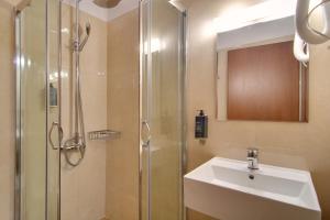 La salle de bains est pourvue d'une douche, d'un lavabo et d'un lavabo. dans l'établissement Ali Pasha Hotel, à Ioannina