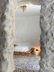 ein Schlafzimmer mit einem Bett in einer Steinmauer in der Unterkunft Vintage House in centro storico Basilicata Puglia in Irsina