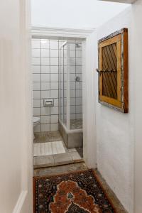 a bathroom with a shower with a door and a rug at 3 Darling Street Guest House in Hanover