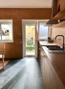 eine Küche mit einem Waschbecken, 2 Fenstern und einem Herd in der Unterkunft Estrelícia in Porto