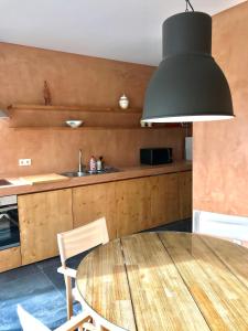 eine Küche mit einem Holztisch und einer schwarzen Beleuchtungseinrichtung in der Unterkunft Estrelícia in Porto