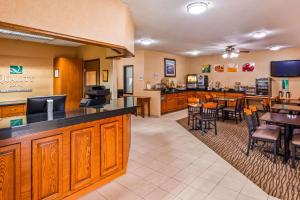 a lobby with a bar and a restaurant with tables and chairs at Quality Inn Tomah in Tomah