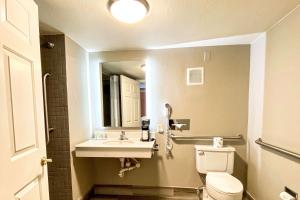 a bathroom with a toilet and a sink and a mirror at Quality Inn Harlingen in Harlingen