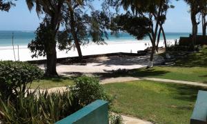 a view of a beach with trees and the ocean at Diani Beachalets in Diani Beach