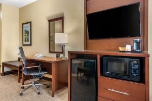 a hotel room with a desk and a television at Comfort Suites Dayton-Wright Patterson in Dayton