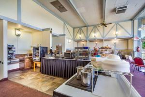 una grande stanza con cucina attrezzata con tavoli e sedie di Hospitality Inn a North Platte