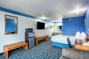 una camera d'albergo con letto e TV di Hospitality Inn a North Platte