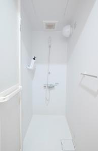 a white bathroom with a shower and a sink at Tottori Guest House Miraie BASE in Tottori