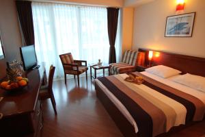 a hotel room with a bed and a table and chairs at Accommodation Dolcino in Ulcinj