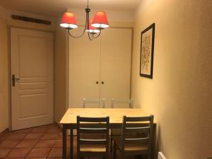 une salle à manger avec une table, des chaises et un lustre dans l'établissement Studio 4 personnes Villa Maldagora Ciboure (St jean de Luz/Soccoa), à Ciboure