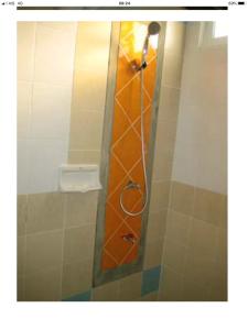 a shower in a bathroom with an orange shower curtain at BM Mansion in Bangna