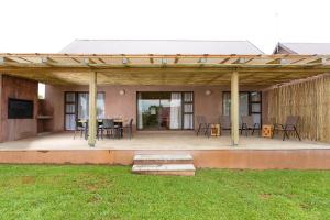 a pavilion with a table and chairs on a patio at The Cottage in Hoedspruit