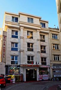 ein großes weißes Gebäude mit einem Laden davor in der Unterkunft Grand Emir Hotel Old City in Istanbul