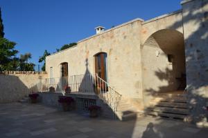 un edificio de piedra con escaleras y un cielo azul en B&B Corte Del Camedrio, en Cisternino