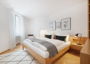 een witte slaapkamer met een groot bed in een kamer bij Franciscus Apartments in Bolzano
