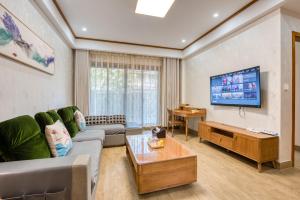 ein Wohnzimmer mit einem Sofa und einem TV in der Unterkunft 拈花湾景区内花园庭院别墅套房---购票入住 in Wuxi
