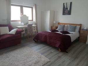 a bedroom with a bed and a chair and a couch at A Beautiful countryside apartment on killarney Road in Mallow