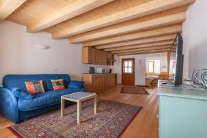 a living room with a blue couch and a table at Casa Piccolin in Falcade