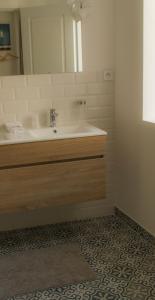 y baño con lavabo y espejo. en LA CENTENAIRE GRUISSAN - Maison d'Hôte, en Gruissan
