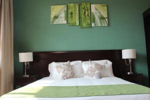a bedroom with a bed with four pictures on the wall at MalVille Boutique Hotel in Lilongwe +41 photos