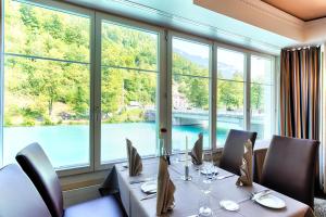 
a dining room table with chairs and a window at Lindner Grand Hotel Beau Rivage in Interlaken
