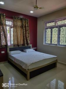 a bedroom with a bed and two windows at Guesthouse Sakina Colva in Colva