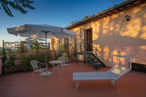 a patio with a table and chairs and an umbrella at Torraccia di Chiusi Agriturismo Relais in San Gimignano
