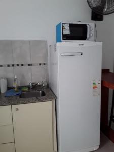 a microwave on top of a refrigerator in a kitchen at El Balcón 2 in Concepción del Uruguay