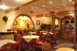 a restaurant with tables and chairs and a kitchen at Hôtel Le Mittelwihr in Mittelwihr