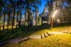 a tiny house in the woods with the sun shining at TonyResort in Trakai