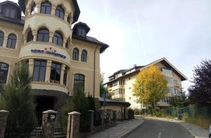 a large yellow building on the side of a street at APARTAMENT MEDIEVAL in Predeal