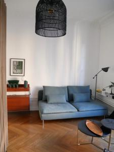a living room with a blue couch and a table at L’Appartement des Glières Annecy centre in Annecy
