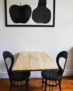 a wooden table with two chairs and an apple picture at L’Appartement des Glières Annecy centre in Annecy