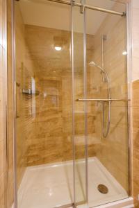 a shower with a glass door in a bathroom at Apartment Ledrar in Bled