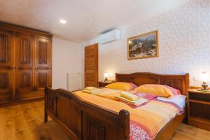 a bedroom with a large wooden bed with two pillows at Apartment Ledrar in Bled